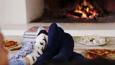 close up of family warming feet by open fire