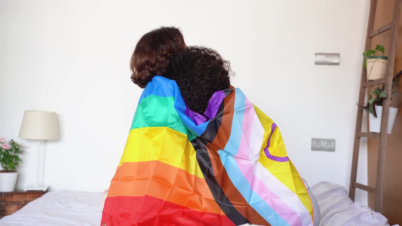 Happy diverse young friends with LGBT flag
