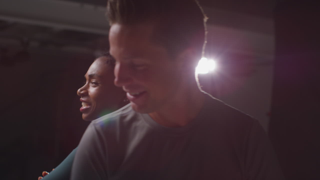 retrato de estudio de una pareja atlética sonriente o amigos en ropa de fitness entrenando en un gimnasio con iluminación de bajo nivel 1
