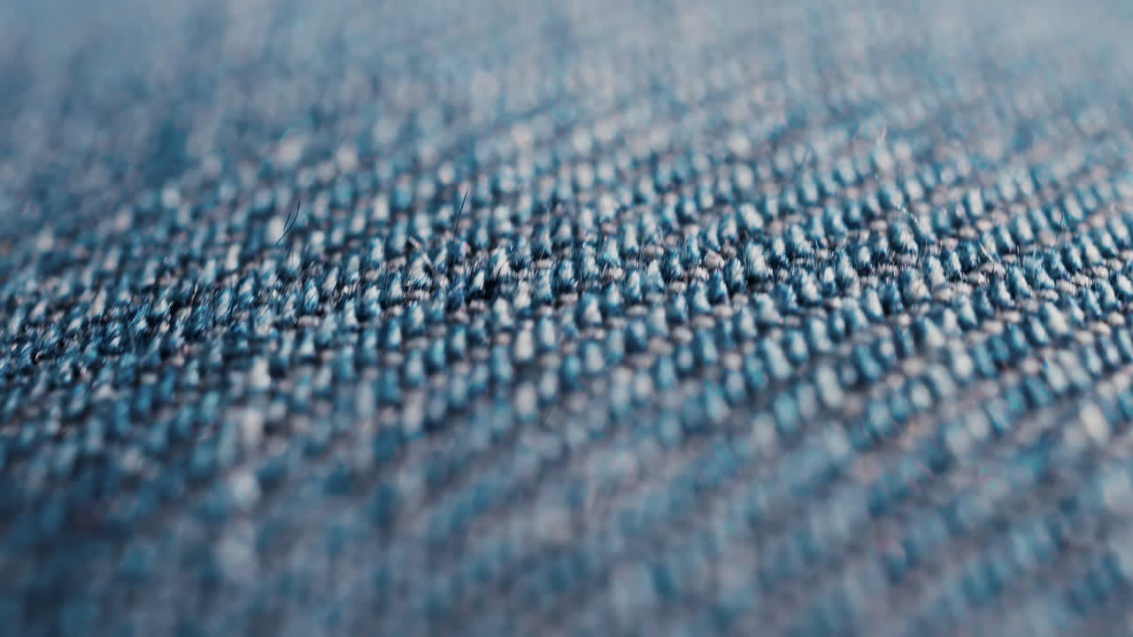 Close up of blue denim fabric texture showing fine threads and detailed textile pattern