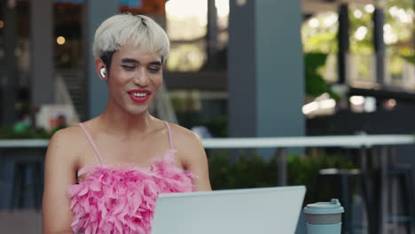 Transgender woman working on a laptop outdoors