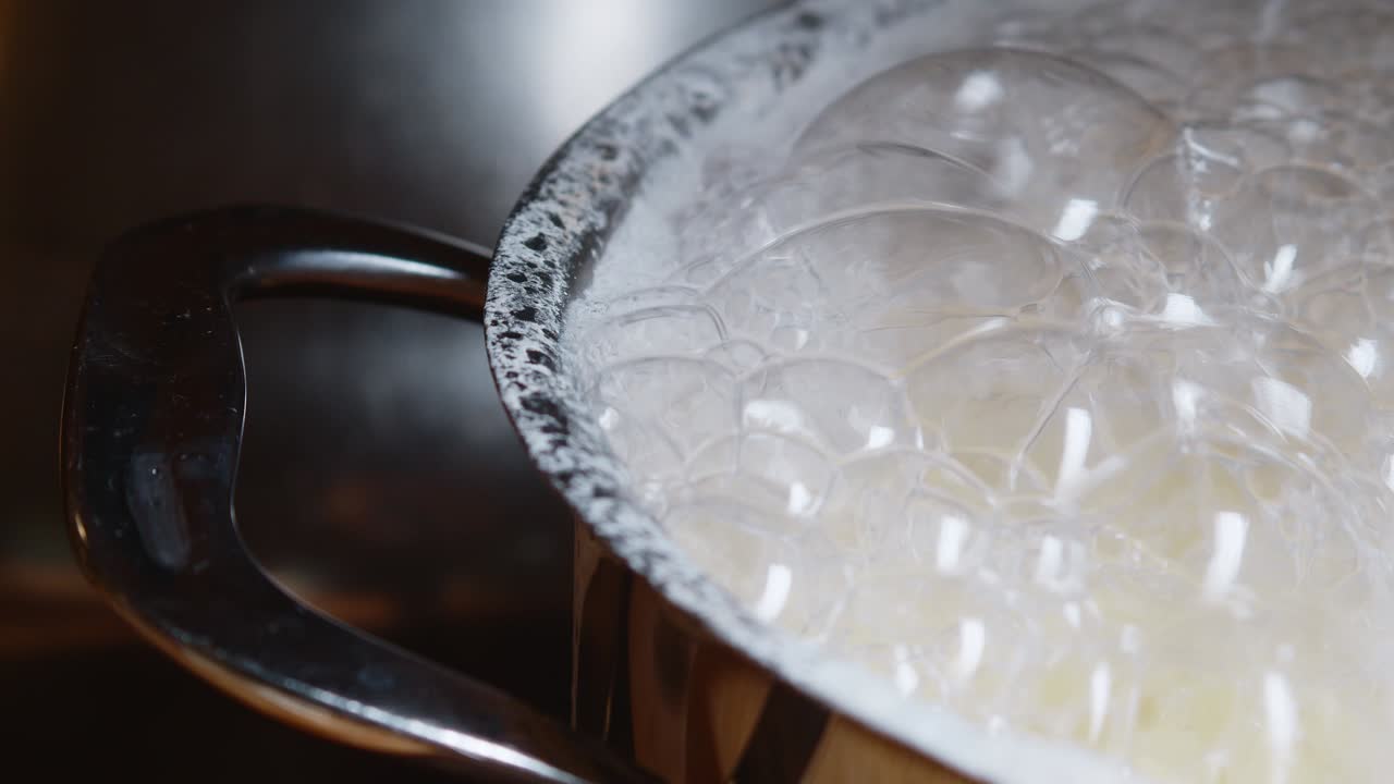 전기레인지 위의 스테인리스 냄비에 끓는 물 위에 거품을