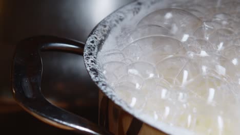 bubbles on top of a boiling water on a stainless pot over the electric stove