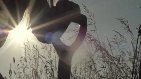 farmer digging in hay field with fork in sunshine