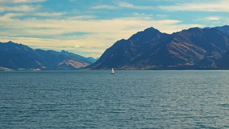 Paralaje-De-órbita-Aérea-Alrededor-De-Un-Velero-En-Medio-Del-Lago-Hawea,-Nueva-Zelanda