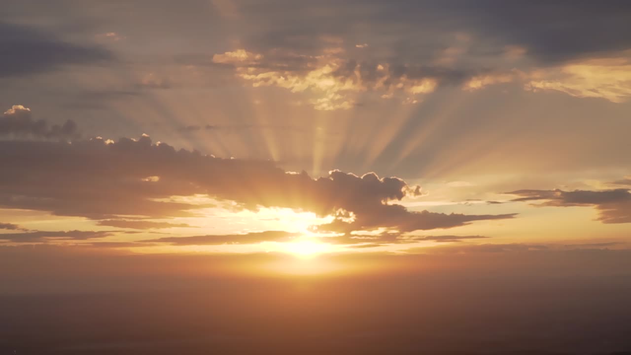 Sunset beautiful rays and clouds seen from the top of a mountain town ZOOM IN