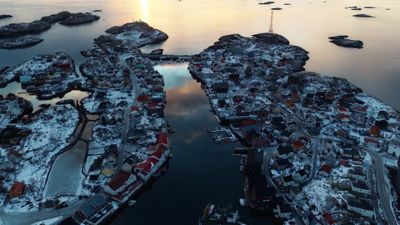 Lähikuva ilmasta lumisesta Henningsvaerin kylästä ja arktisista vesiväylistä, drone.