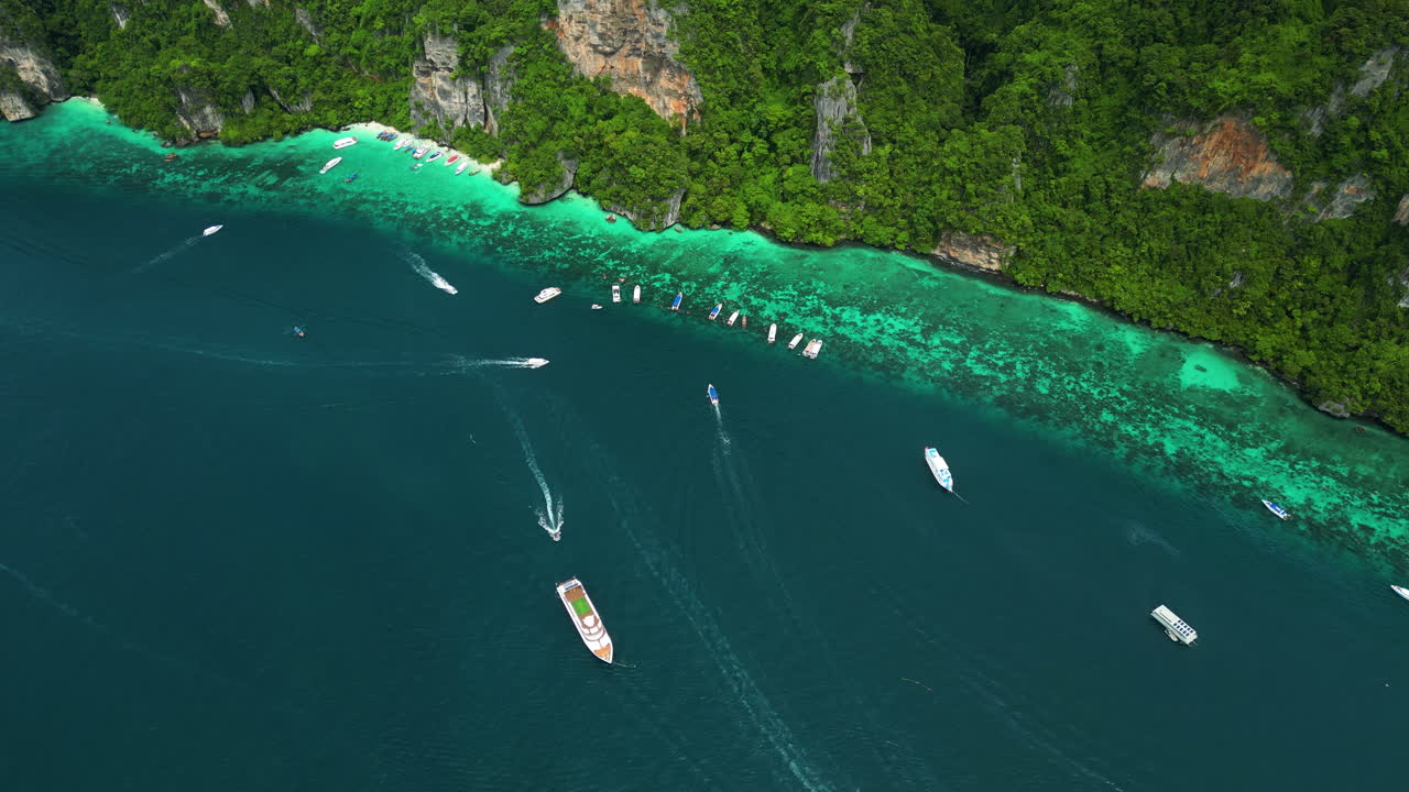 Boats anchored along edge of touristy attraction, Pi Leh lagoon, Thailand