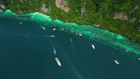 boats anchored along edge of touristy attraction, pi leh lagoon, thailand