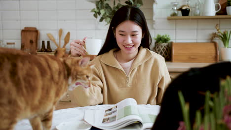 woman with cats in the kitchen table