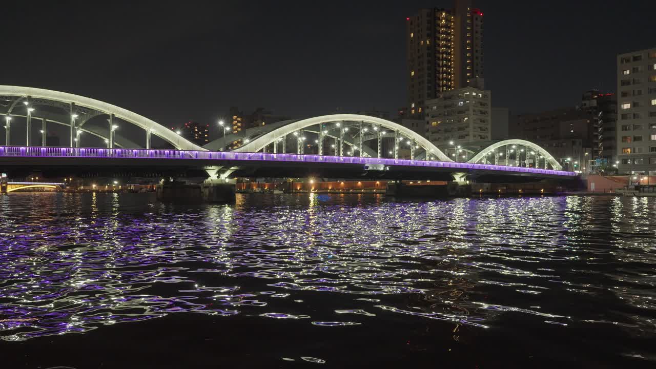 Night cityscape with illuminated bridge over water