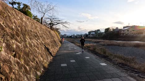 person jogging beside river canal in kyoto