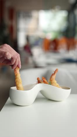 mujer comiendo camarón tempura