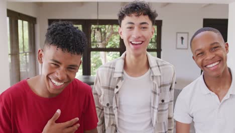 retrato de felices y diversos amigos adolescentes hombres abrazándose en casa, en cámara lenta.