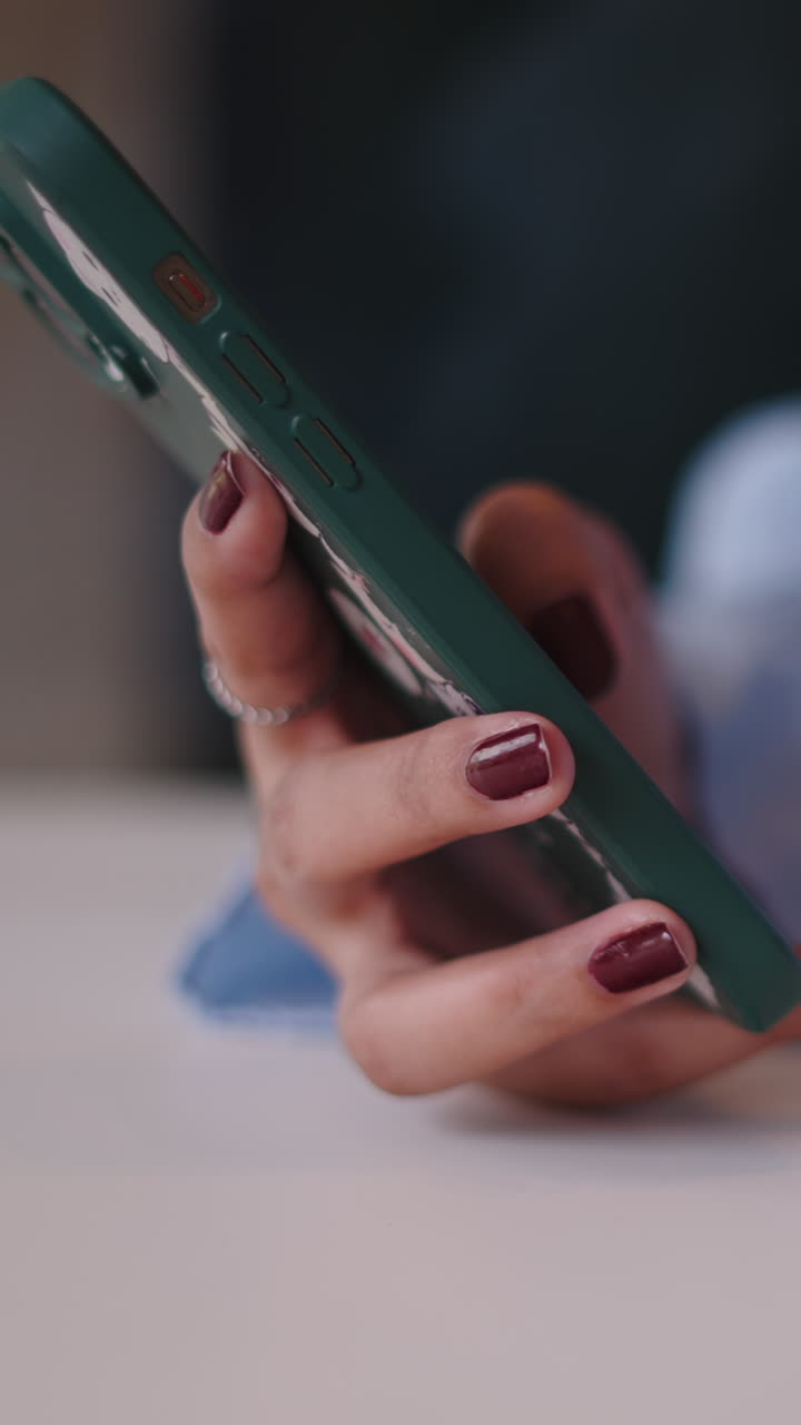 Primo piano di una mano che tiene e usa uno smartphone