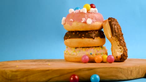 steady shot of a pile of donuts, grabbing a bite and placing it back