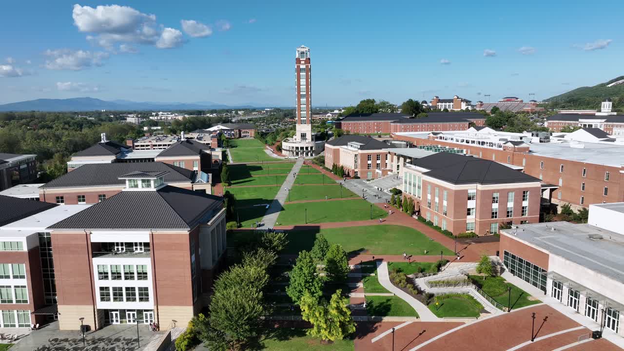 Campus buildings and houses of liberty university in Lynchburg, Virginia. Sunny evening in late summer. Red brick facade of freedom tower. Aerial wide shot