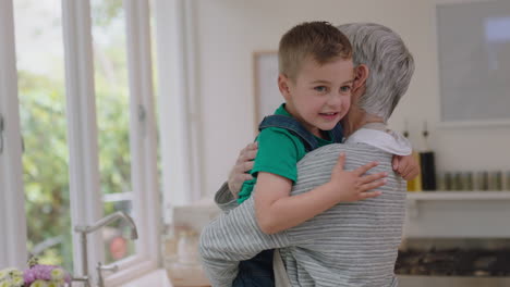 niño feliz abrazando a la abuela sonriendo abrazando a su nieto amando a la abuela disfrutando del afecto en casa concepto familiar 4k metraje