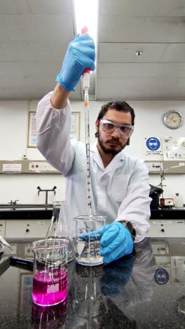 scientist using pipette bulb to transfer liquid