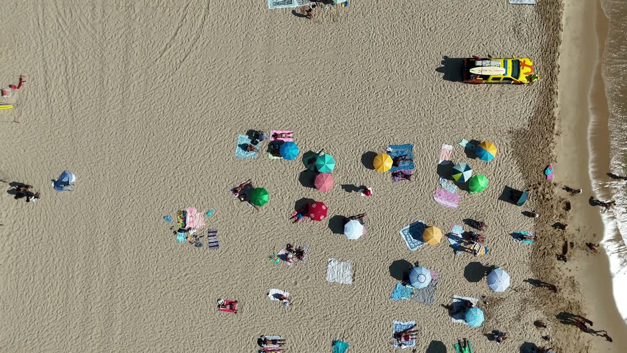 Aerial view of a beach with people and umbrellas