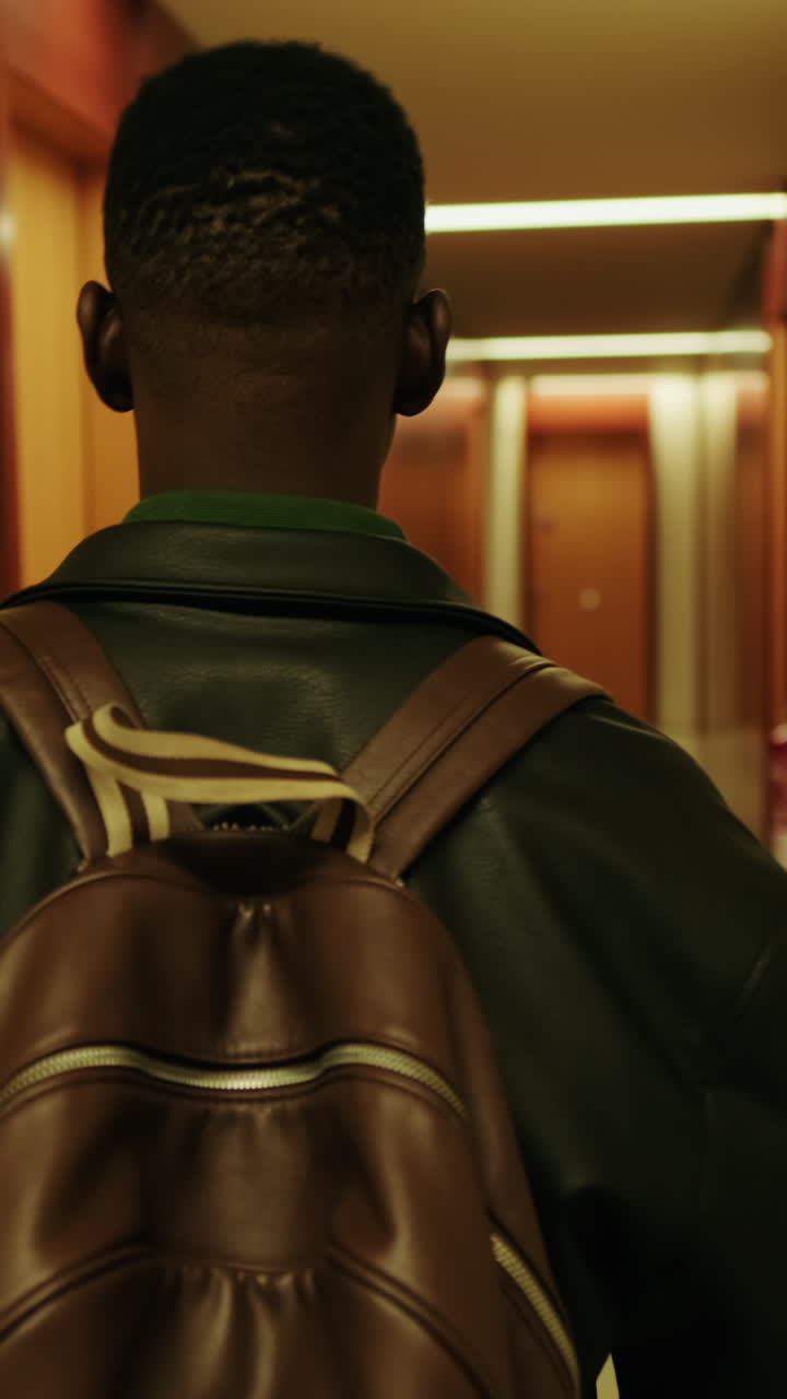 Person with Backpack Walking Through a Dark Hallway