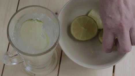 dejando caer rodajas de limón en un vaso de agua con gas