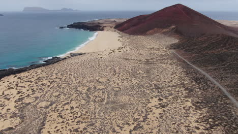 la graciosa island: aerial view traveling out to bermeja mountain and las conchas beach on a sunny day and turquoise waters