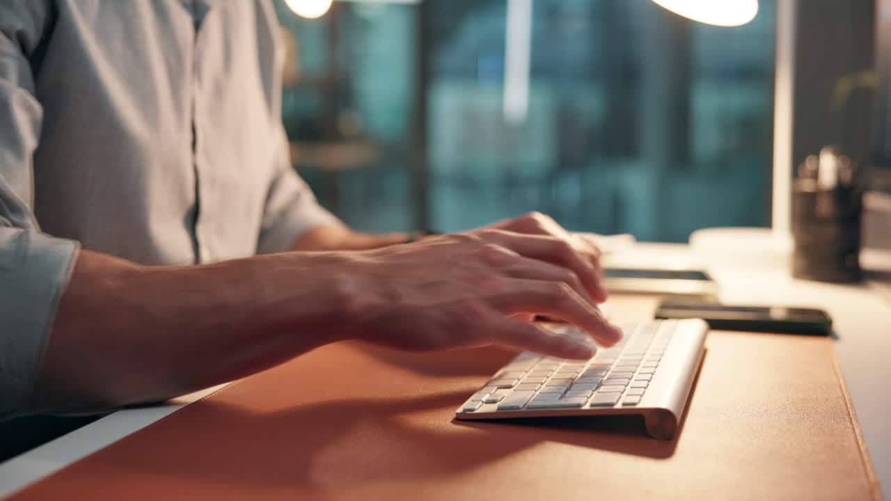 Close-up of Man's Hands Typing on Computer Keyboard at Office Desk