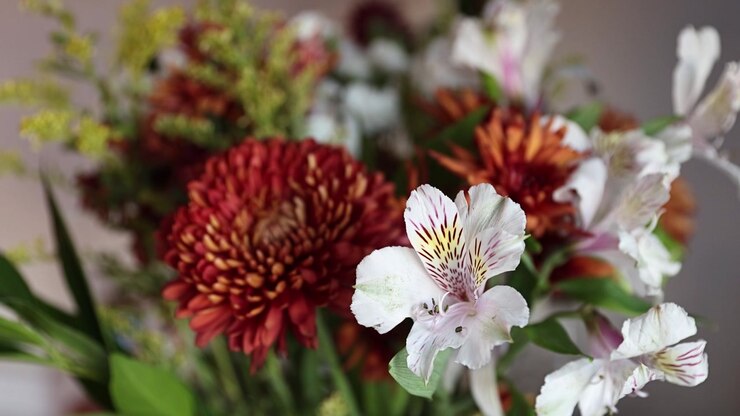white tiger lily in a beautiful vibrant bouquet with florist daisies and other flowers blurred in the background STATIC