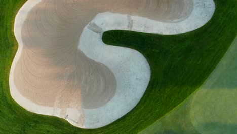 Top-down-rising-aerial-reveals-sand-bunker-hazard