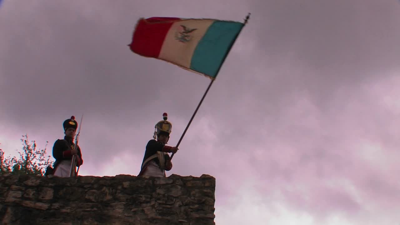 알라모 전투 재현에서 군인이 멕시코 국기를 흔드는 모습
