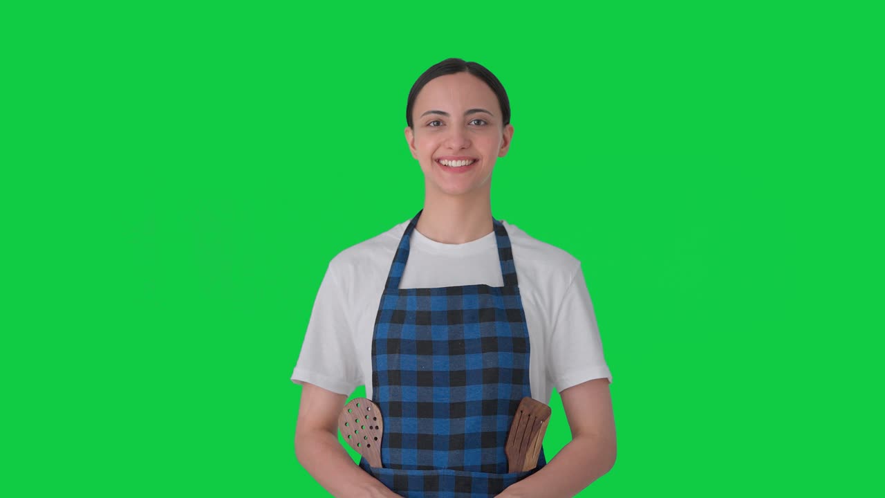 Casalinga indiana felice che sorride alla telecamera Green screen