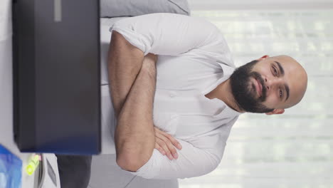 Vertical-video-of-Home-office-worker-man-makes-a-trust-sign-to-the-camera.