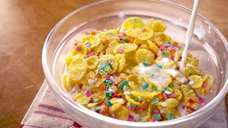 flocos de maíz amarillos crujientes en el cuenco para la mañana un delicioso desayuno con leche. cámara lenta con toma de seguimiento de rotación.