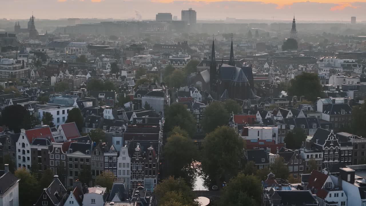 Morning sun frames a shadowed Amsterdam church in a graceful aerial reveal