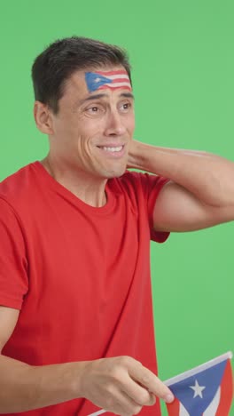 nervous man cheering for puerto rico during a match looking away