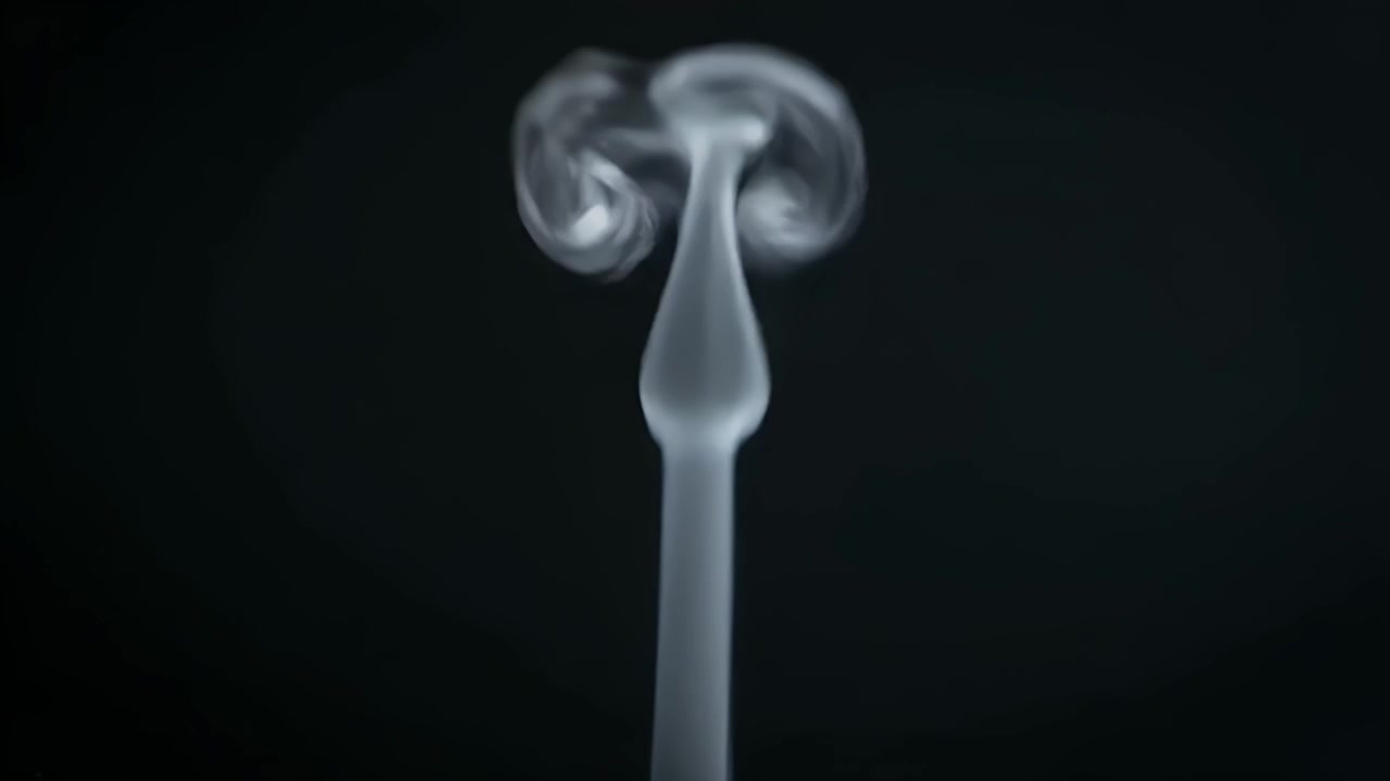 Thin Stream of White Smoke Rising Against a Black Background
