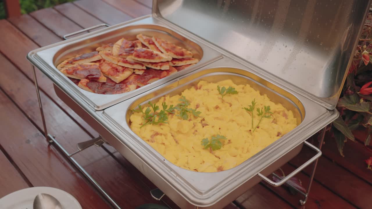 Metal buffet trays filled with pizza slices and polenta served for catering event