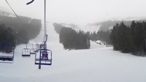 chairlift with skiers and snowboarders at a ski resort in alberta, canada