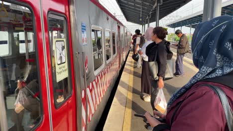 people boarding a train at a railway station in indonesia