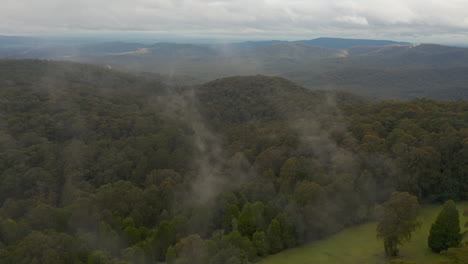 Camera-smoothly-pushing-forward-through-fog-over-a-serene-natural-landscape