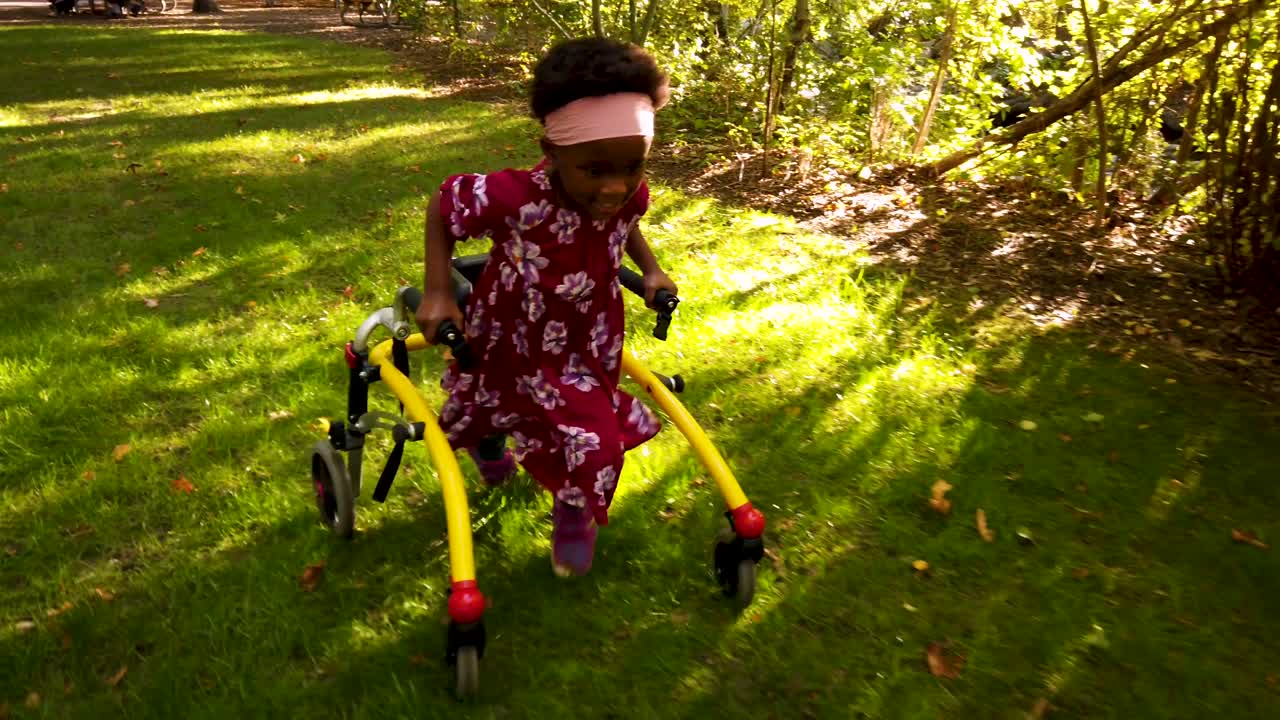 Black girl with Cerebral Palsy walking in the park with her assistive device-1