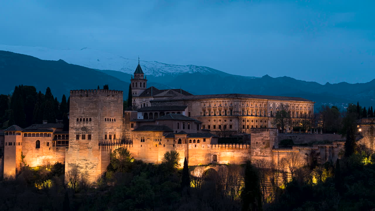 lapso de tiempo de día a noche - complejo del palacio nazarí de la alhambra iluminado por la noche