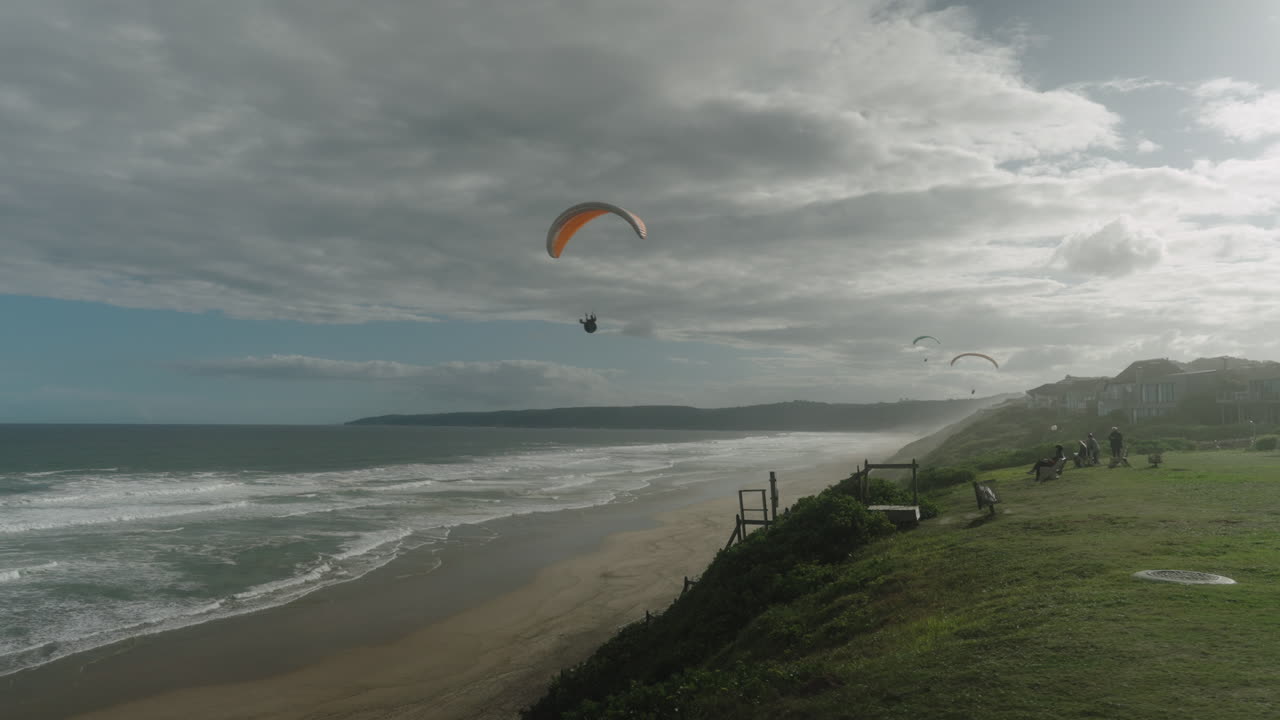 Parapentistas volando junto a la playa.