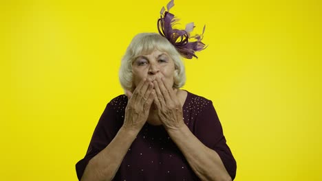 happy senior old woman sending air fly kisses to camera, demonstrating love, romantic emotions