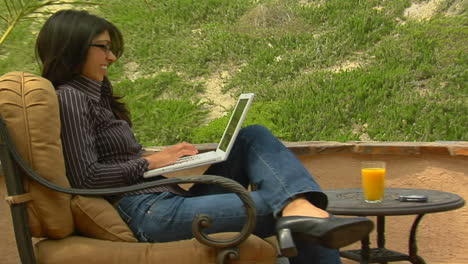 a woman works on a laptop computer in an outdoor setting