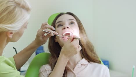 Young-woman-having-teeth-examination-at-dentist.-Professional-oral-checkup