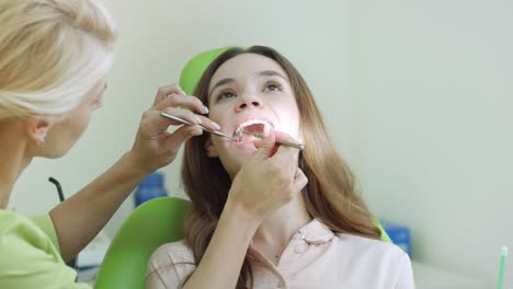 mujer joven que tiene un examen dental en el dentista. chequeo oral profesional
