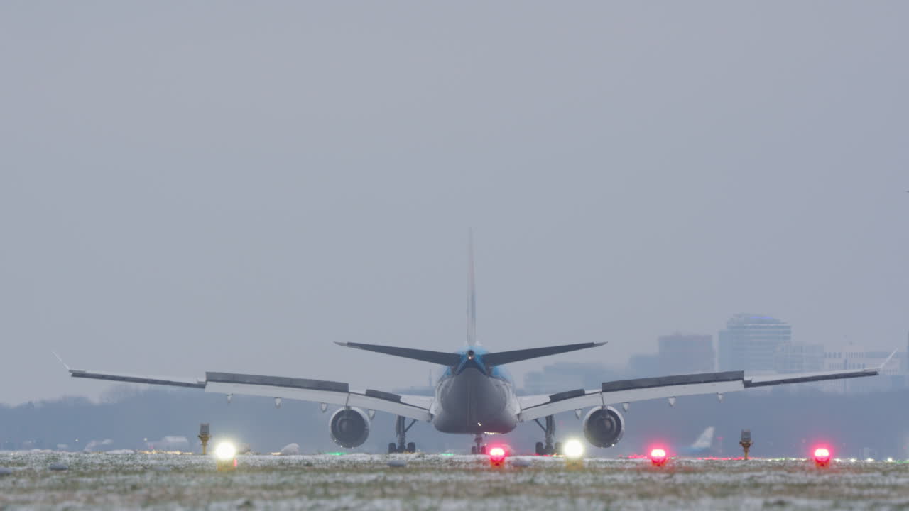 Aereo di linea di grandi dimensioni che atterra su una pista invernale nebbiosa.