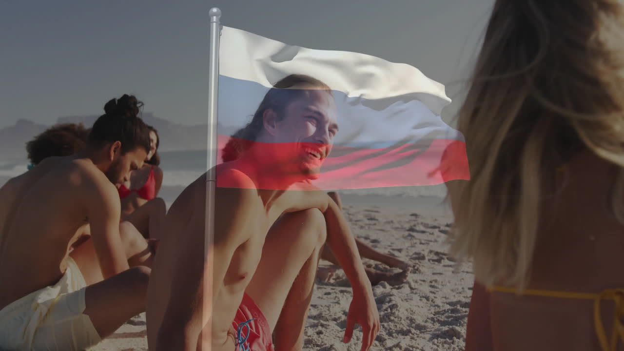 On beach, young people relaxing with animation of Russian flag overlaying scene